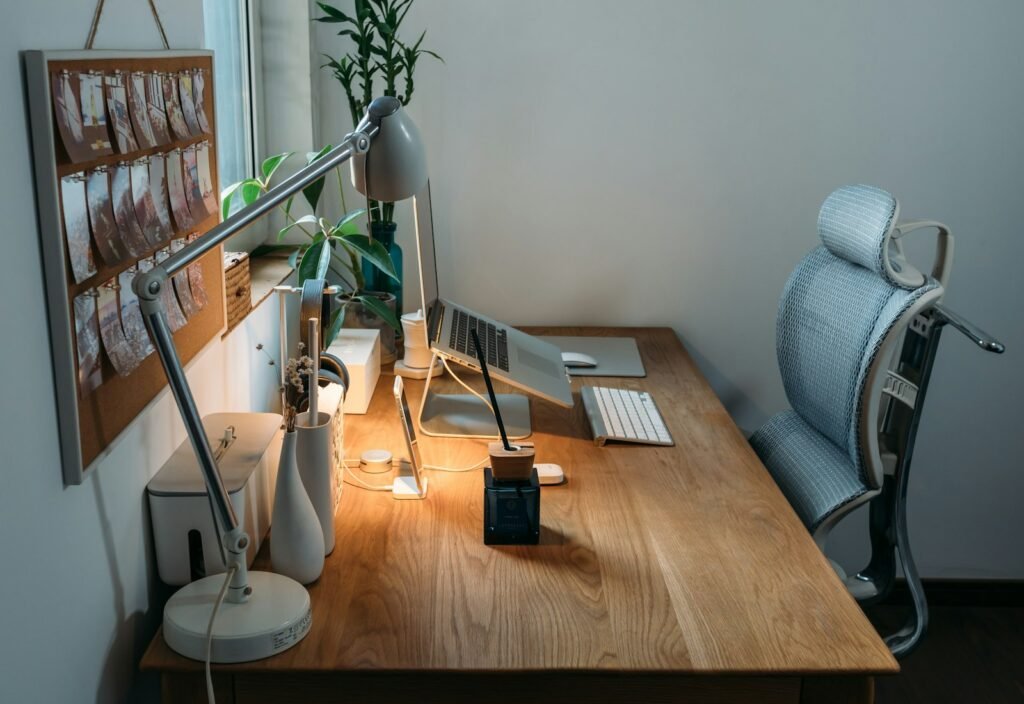 Bureau placé près d’une fenêtre avec une lampe de bureau orientable