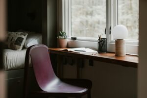 Petit coin bureau près d’une fenêtre avec chaise et plante