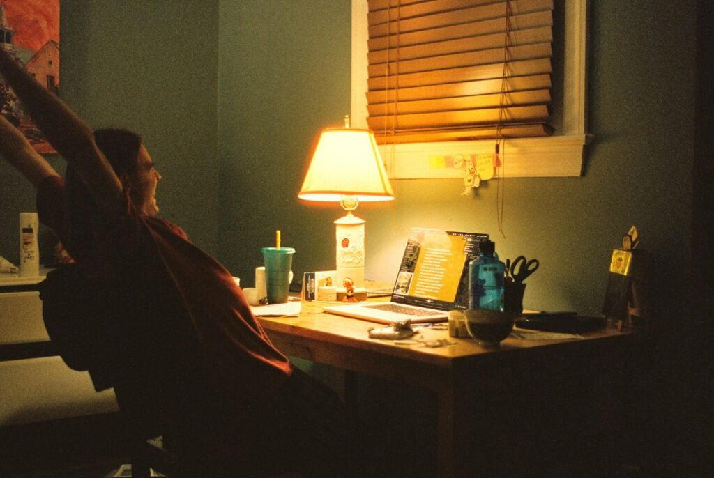 Personne travaillant le soir à son bureau sous une lampe